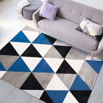 THE DECO FACTORY Geo scandi - Tapis toucher laineux motif triangles bleu 150x220 - Bleu